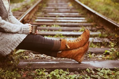 Premium Photo Young Woman Sitting On Rail Track