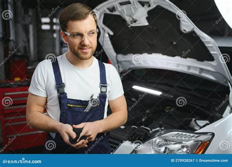Portrait Of A Happy Auto Mechanic Cleaning Hands With Cloth Stock Image