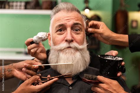 An Older Man With A White Beard Is Shaved Combed Hair Cut By Several
