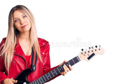 Young Beautiful Blonde Woman Playing Electric Guitar Thinking Attitude