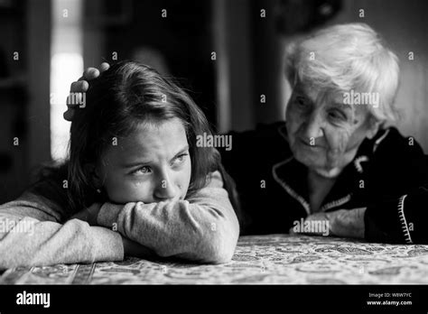 Une petite fille pleure sa grand mère sa main tapote sur la tête Photo en noir et blanc Photo