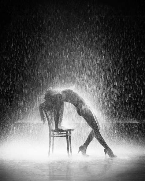 A Woman Sitting On A Chair In The Rain With Her Head Down And Hands Under Her Knees