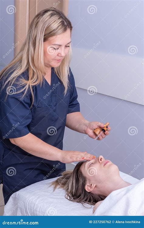 Girl Masseur Drips Essential Oil With A Pipette On The Girland X27s Face