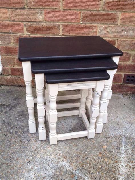 Three White And Black Nesting Tables Sitting Next To Each Other On The