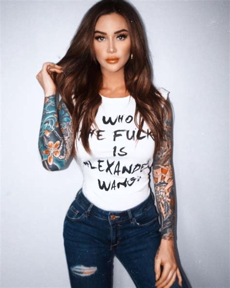 A Woman With Tattoos On Her Arms And Arm Is Posing For The Camera While
