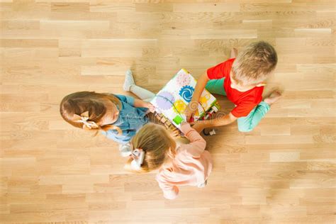 Top View Of Children Playing With Busy Board At Home Stock Photo
