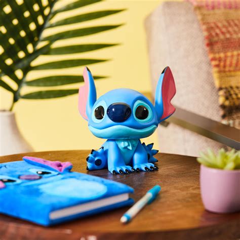 A Blue Toy Sitting On Top Of A Wooden Table Next To A Potted Plant