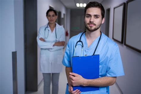 Portrait Of Male Nurse Standing With Doctor In Background Stock Photo