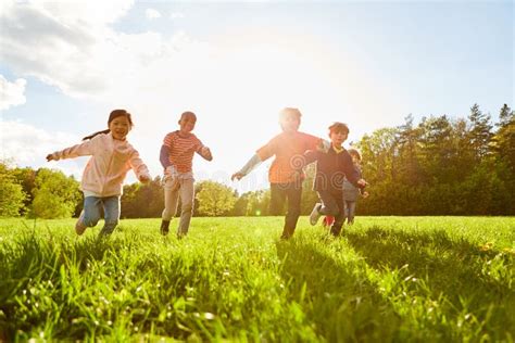 Children Run And Play In A Meadow Stock Photo Image Of Competition
