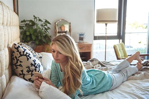 Caucasian Woman In Her Bedroom Texting On Her Mobile Cell Phone By Stocksy Contributor Daxiao