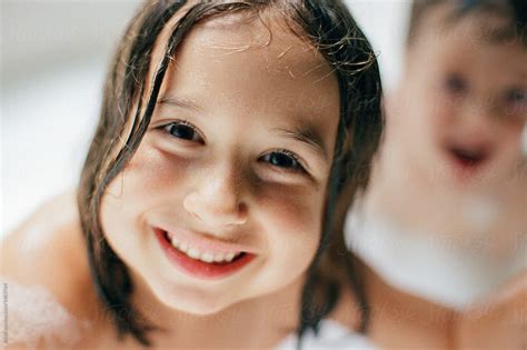 Cute Young Girl Sitting In A Bathtub Smiling At Camera By Stocksy Contributor Jakob