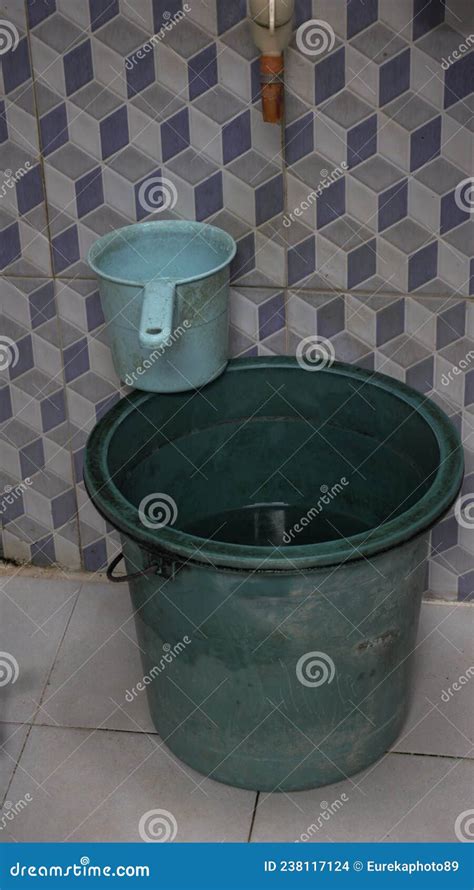 Dirty Plastic Bucket For Water Reservoir On A Traditional Bathroom With