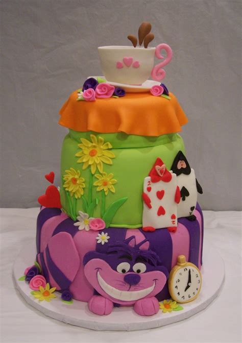 A Multi Layer Cake Decorated With Cartoon Characters And Flowers On A