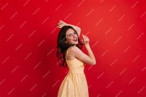 Free Photo Mischievous Curly Lady Is Dancing On Red Wall Brunette In