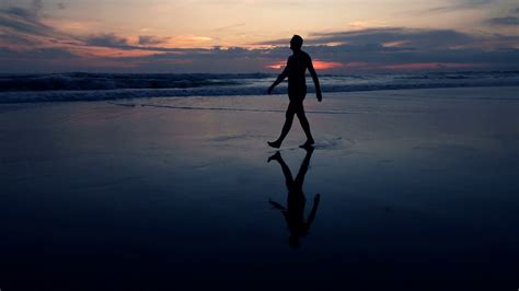 Silhouette Of Man Walking Ont The Beach During Sunset Super Slow