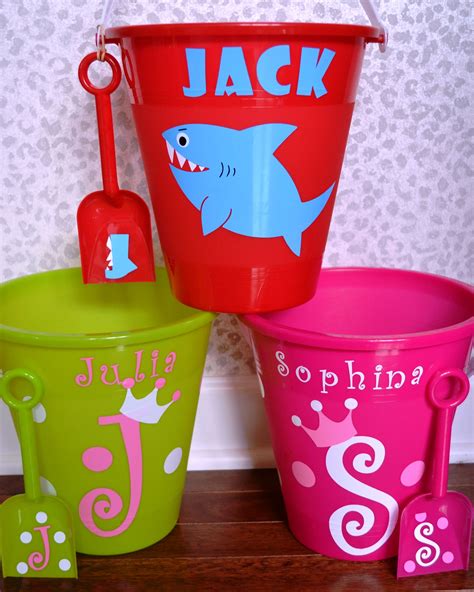 Three Plastic Buckets With Different Designs On Them One Has A Shark