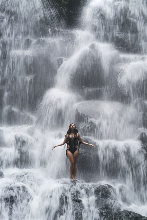 Girl In Swimsuit Standing Under Waterfall Vertical Oriented By Stocksy Contributor Nick