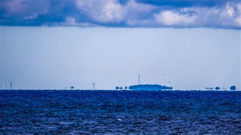 Fata Morgana Mirage Of Coastline With Wind Turbines Stock Image