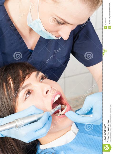 Pretty Woman Patient Having Mouth Checkup At The Dentist Stock Photo