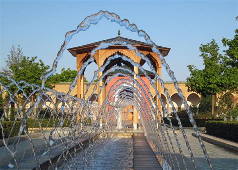 Eine quadratische gartenfläche mit einem wegekreuz aus hellem kies, pflanzflächen aus buchs und weiß blühenden stauden sowie einem wasserbecken als symbol für das wasser als quelle des lebens. "Gärten der Welt" Berlin Erholungspark Marzahn von ballpen ...