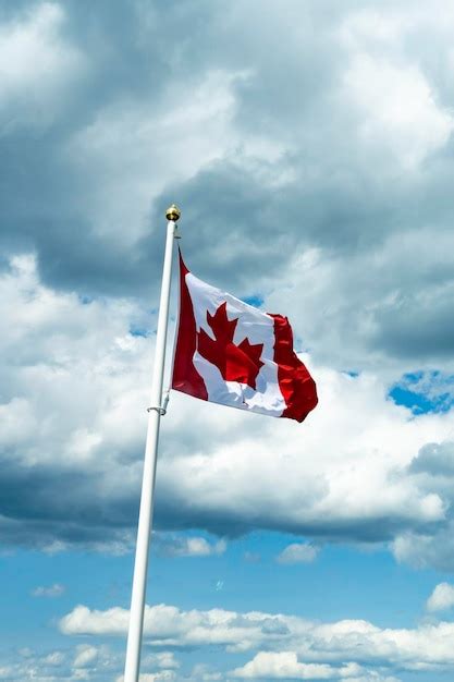 Premium Photo Canadian Maple Leaf National Flag Flying Over Mountains