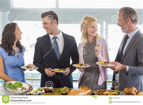 Business Colleagues Interacting While Serving Themselves At Buffet