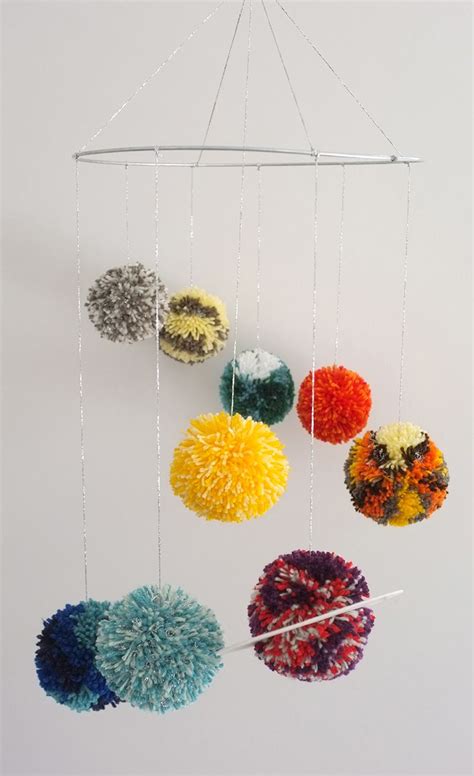 Loop the thread through each hole to attach the planets. Make a solar system pom pom mobile for the nursery ...