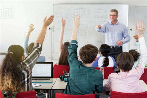 Male Teacher Calling On Students In Classroom Stock Photo Dissolve