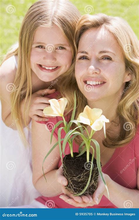 Madre E Hija Al Aire Libre Que Sostienen La Flor Imagen De Archivo