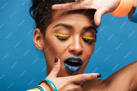 Free Photo Horizontal Stylish Mulatto Woman With Colorful Makeup And Curly Hair In Bun Holding