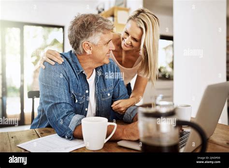 Mature Couple Talking And Browsing On A Laptop While Spending Time