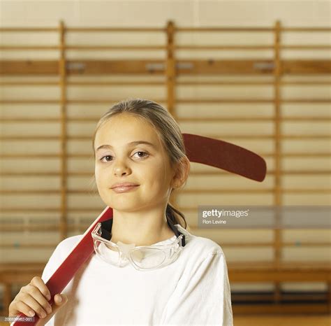 Girl With Hockey Stick In School Gym Portrait High Res Stock Photo