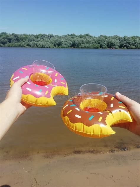 Round Inflatable Circles In The Form Of A Donut In The Hands Of Two