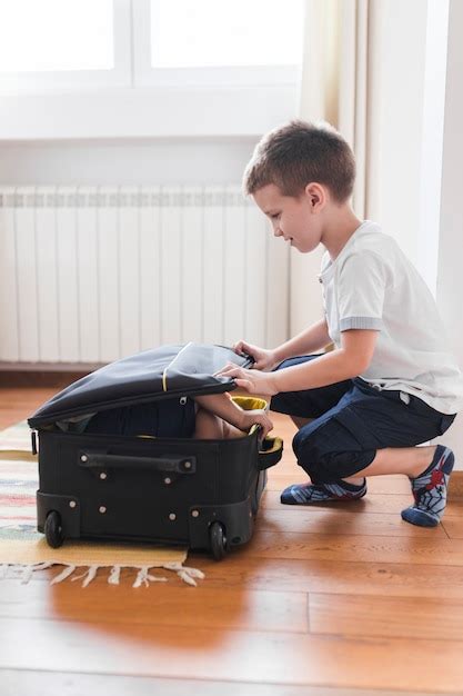 Free Photo Boy Packing His Brother In Luggage
