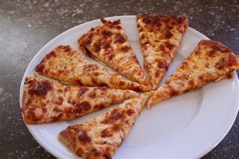 Four Slices Of Pizza On A White Plate