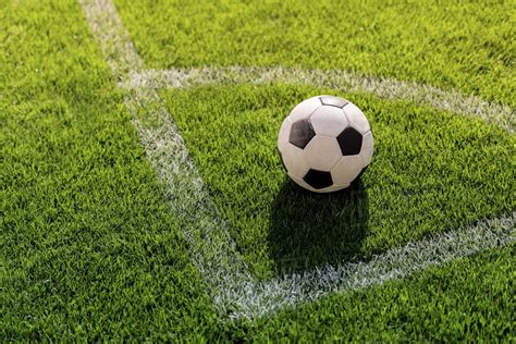 Its dimensions and markings are defined by law 1 of the laws of the game, the field of play. Soccer ball on grass in corner kick position on soccer ...