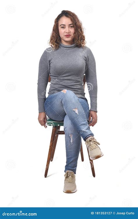 Portrait Of A Woman Sitting On A Chair In White Background Looking At Camera And Legs Crossed