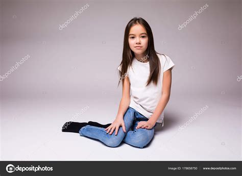 Lovely Little Girl Sitting On The Floor On White Background Stock Photo