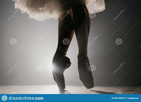 Close Up Of Ballet Dancer As She Practices Exercises On Dark Stage Or
