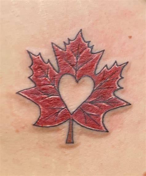 A Heart Shaped Leaf Tattoo On The Back Of A Womans Shoulder