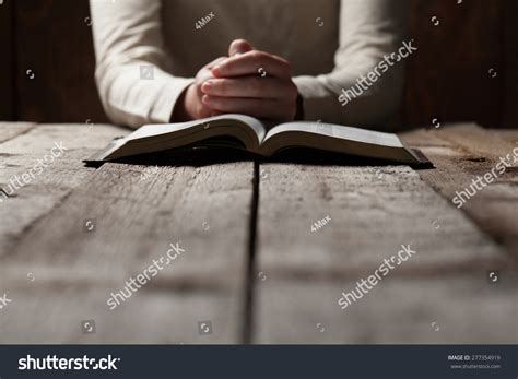 Woman Hands Praying With A Bible In A Dark Over Wooden Table Stock