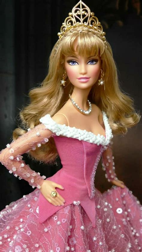 a barbie doll wearing a pink dress and tiara with pearls on it s head