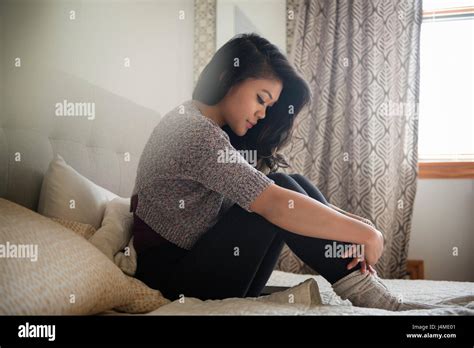 Depressed Mixed Race Woman Sitting On Bed Stock Photo Alamy