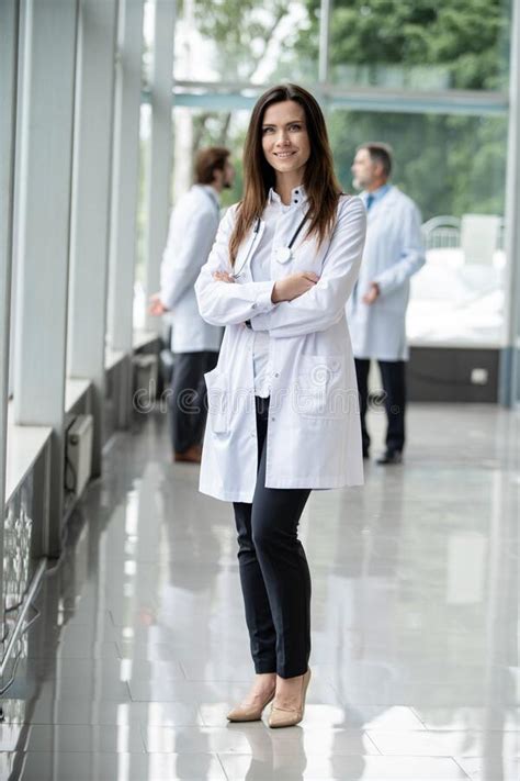 Portrait Of Young Woman Doctor With White Coat Standing In Hospital