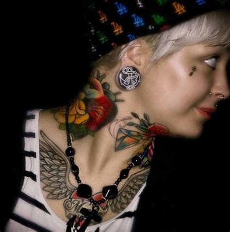 A Woman With Tattoos On Her Neck And Chest