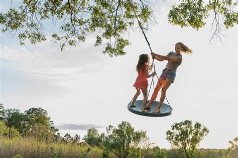 Kids Standing And Balancing On Tree Swing Summer Bliss By Stocksy