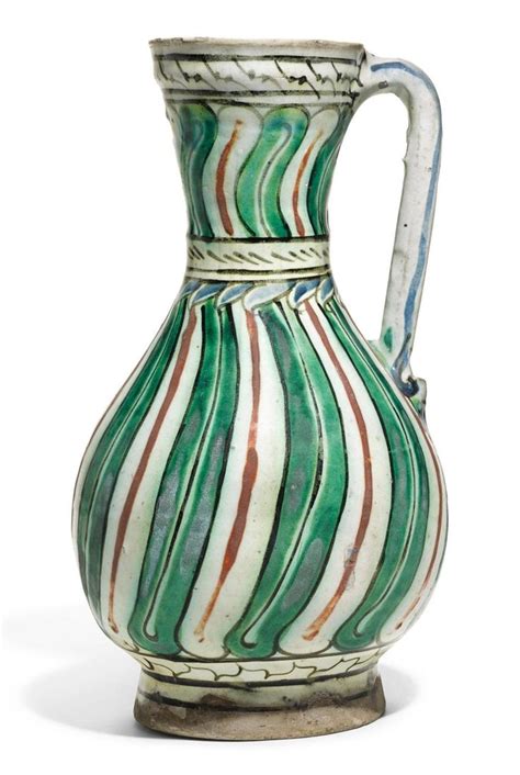 Sold At Auction AN IZNIK POLYCHROME POTTERY JUG WITH VERTICAL BAND