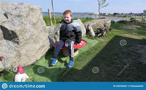 Muchacho De Cabeza Roja Sentado En Una Irlanda De Setas Imagen De
