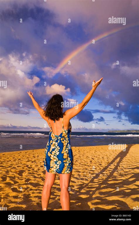Rainbow Over Woman Raising Arms On Tunnels Beach At Sunset Island Of