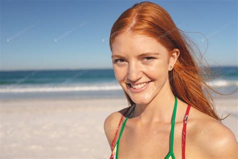 Portrait Of Caucasian Happy Redhead Woman Standing On The Beach By